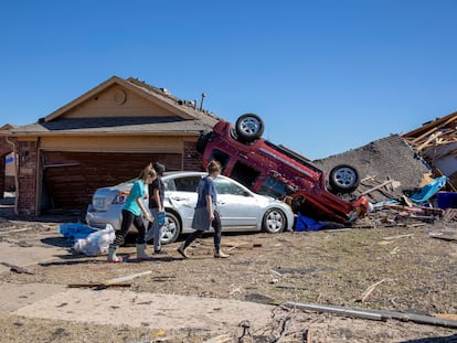 Neighbors walk in front of a home damaged at Wheatland Drive and Conway Drive on Monday, Feb. 27, 2023 in Norman, Okla.