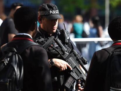 Un policía armado frente a unos estudiantes en una calle de Mánchester, este jueves.