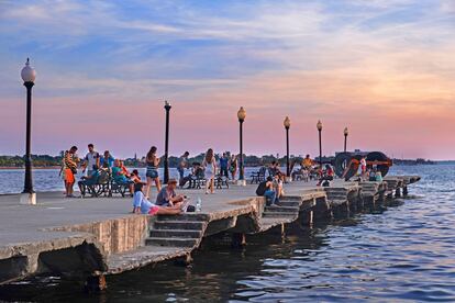 Paseantes disfrutando del Muelle Real de Cienfuegos.