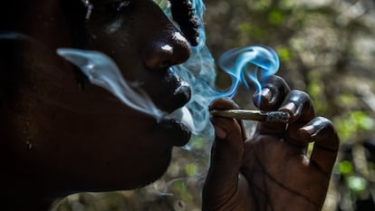 Una persona fuma un porro en un bosque de Kenia.