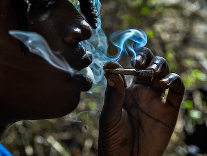 Una persona fuma un porro en un bosque de Kenia.