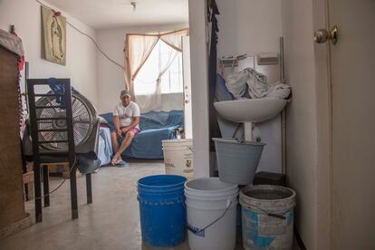 La familia Duque Martínez en el interior de su vivienda muestra los botes con agua que almacena tras la escasez de agua que afecta la zona metropolitana de Monterrey, Nuevo León.