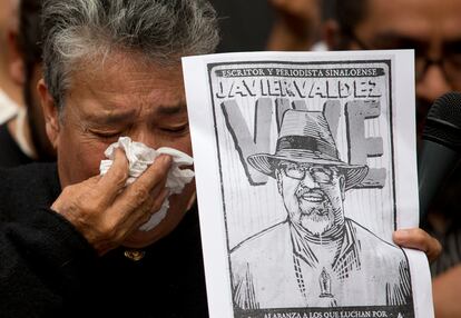 La activista Maria Herrera con una imagen del periodista Javier Valdez durante un protesta en Ciudad de México, en 2017