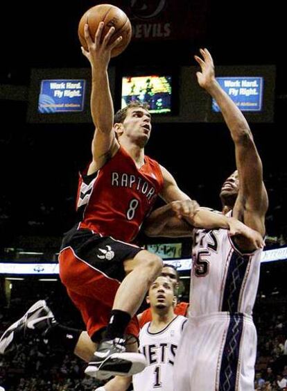 El base espa?ol de los Raptors Jose Caldern entra a canasta ante la oposicin de dos jugadores de los Nets de Nueva Jersey.