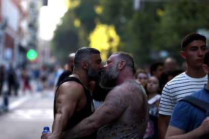 Dos participantes en la marcha del Orgullo en Madrid se besan. 