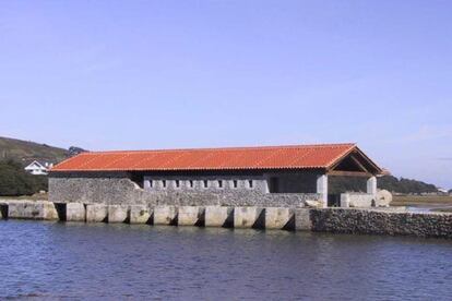 Una vista del molino de Santa Olaja con la marea alta, reconstruido como museo, en Arnuero (Cantabria).