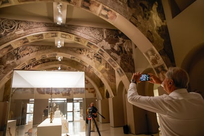 Un home fotografia els murals provinents de Sixena al MNAC
