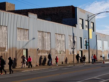 People stand outside a migrant shelter near the 2300 block of South Halsted Street, on Dec. 19, 2023, in Chicago.
