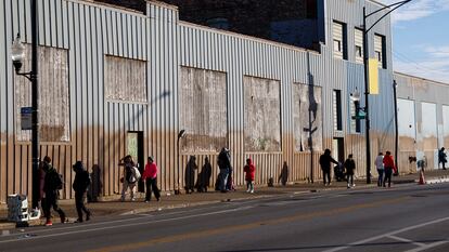 Personas caminan afuera de un refugio para migrantes en Chicago, en diciembre 2023.