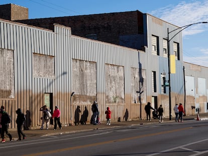 People stand outside a migrant shelter near the 2300 block of South Halsted Street, on Dec. 19, 2023, in Chicago.