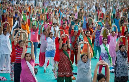 Personas realizan yoga durante una sesión de entrenamiento antes del Día Internacional del Yoga, en Ahmedabad (India).