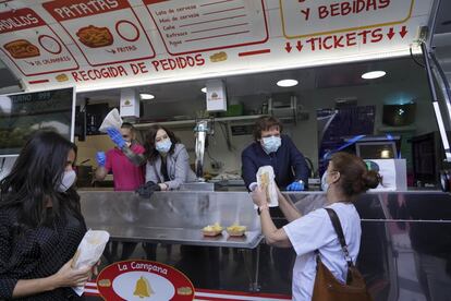 El alcalde de Madrid, José Luis Martínez Almeida entrega un bocadillo de calamares a una sanitaria en una 'food truck' mientras es observado por la presidenta de la Comunidad de Madrid, Isabel Díaz Ayuso. A la izquierda, aparece la vicealcaldesa Begoña Villacís, obsequiada con otro bocadillo de calamares durante la clausura del hospital de campaña en el Ifema.