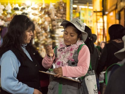 Una de las brigadistas de Ladies Hope le enseña a una mujer cómo realizarse la prueba para detectar el cáncer de cuello uterino, en  un mercado de Lima.