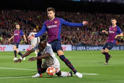 Sadio Mane del Liverpool pelea un balón con Gerard Piqué. 