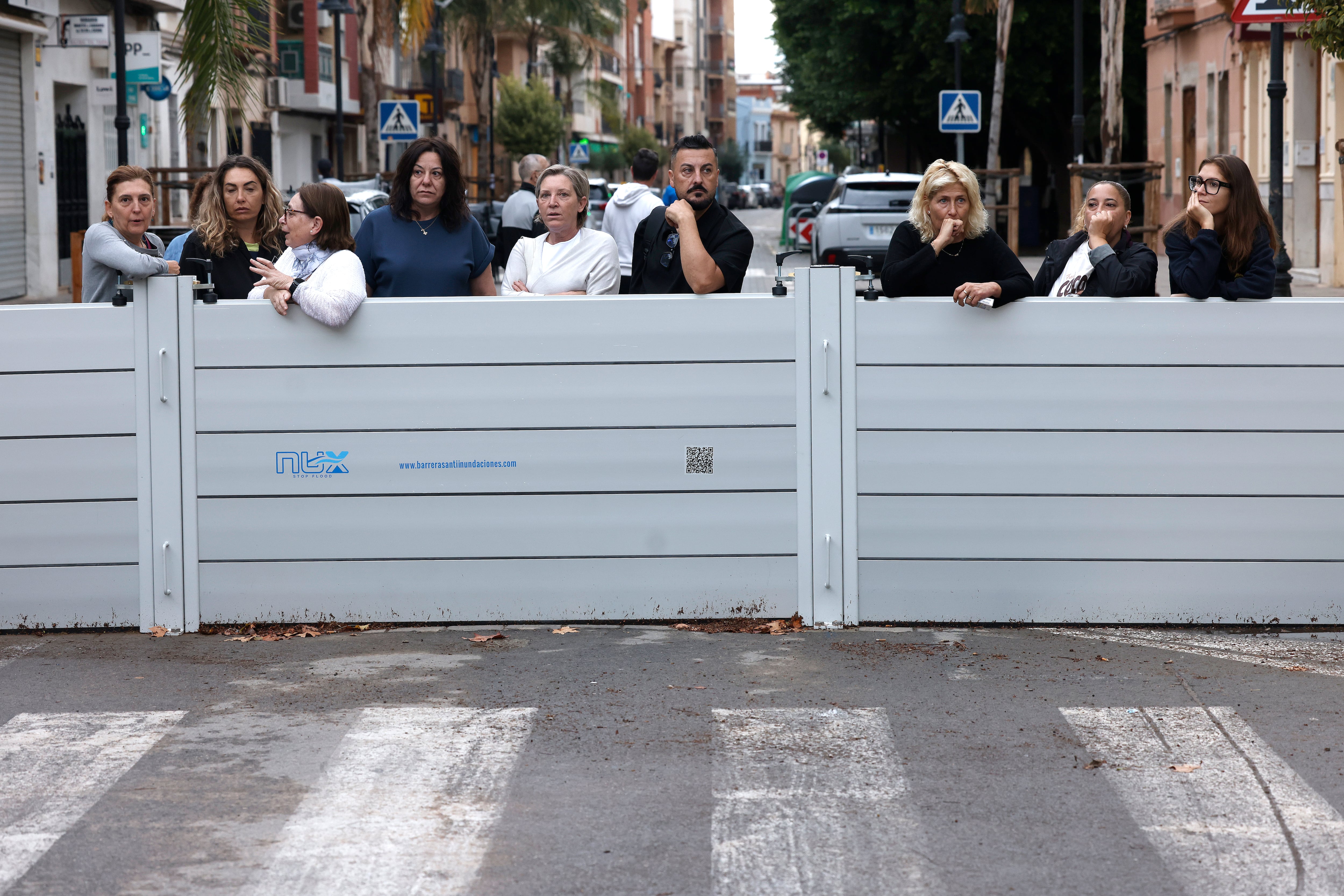 Vecinos detrás de las barreras protectoras que han instalado en la población de Aldaia (Valencia), este lunes. 