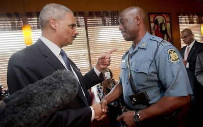 Holder junto al polic&iacute;a encargado de supervisar las protestas.