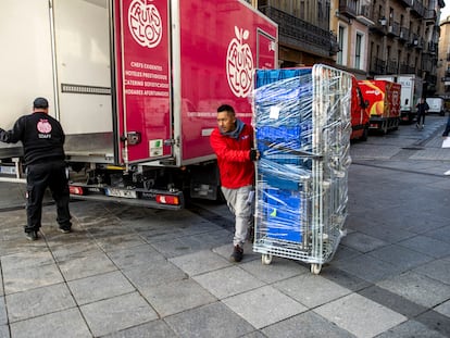 Varios trabajadores descargan material de un camión en Toledo.