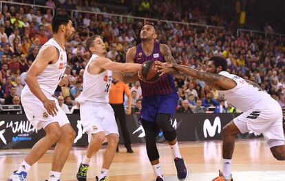 El húngaro del Barcelona Lassa Ádám Hanga en acción entre los jugadores del Real Madrid Jaycee Carroll y Trey Thompkins.
