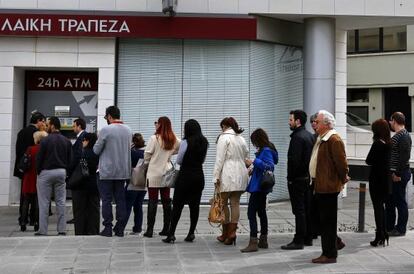 Clientes hacen cola ante un cajero del Banco Popular de Chipre.