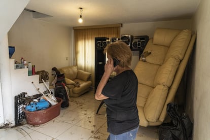 Alejandra Pineda llama por teléfono en su casa en Atizapán, en el Estado de México. Todos los muebles en la planta baja de su domicilio quedaron inservibles por las fuertes corrientes de agua.