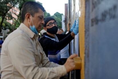 Operarios colocan las listas con la identificación de votantes en el exterior de un centro en Caracas. Una delegación parlamentaria de Irán, país aliado de Caracas, se encuentra en Venezuela para supervisar las elecciones legislativas que se celebran este domingo, en las que la oposición ha llamado a la abstención.