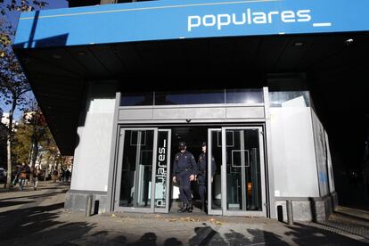 Agentes del Cuerpo Nacional de Policía en la puerta de la sede del Partido Popular en Génova, durante el registro realizado por la comisión judicial enviada por el juez Pablo Ruz por las obras de reforma de dicha sede, investigadas por un posible delito fiscal dentro del 'caso Bárcenas', en diciembre del 2013.