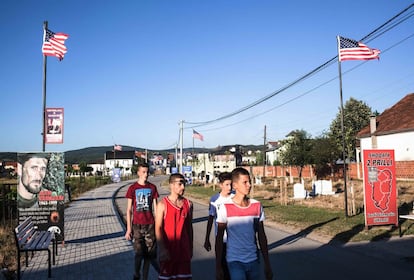 Un grupo de jóvenes pasea por una calle de Llashticë, un pueblo al sureste de Kosovo, engalanada con banderas de Estados Unidos. El alcalde ha invertido miles de euros en decoración para mostrar gratitud hacia el país norteamericano.