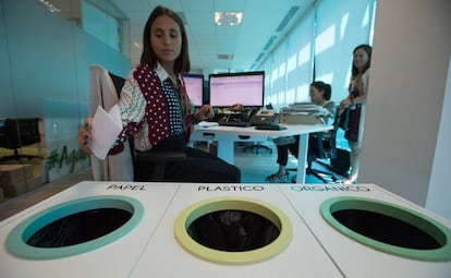 Una trabajadora de la empresa de cosmética Yves Rocher tira un papel en las papeleras de reciclaje que hay en las oficinas de la compañía en Madrid.