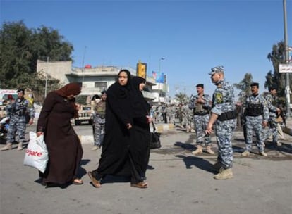 Mujeres iraquíes pasean por el centro de Bagdad con soldados estadounidenses vigilando las calles.