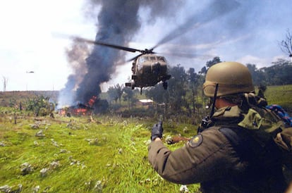 A Colombian police officer from an anti-narcotics task force torches a cocaine laboratory in Tibú, in 2000. 