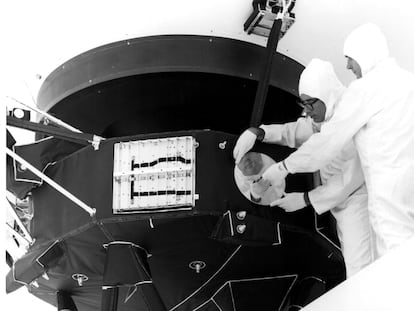 Dos ingenieros instalan el disco dorado en la sonda Voyager, en una imagen de archivo de 1977.