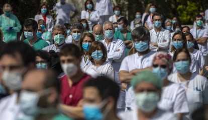 Health workers at the La Paz hospital in Madrid hold a minute of silence in tribute to a doctor who died from Covid-19.