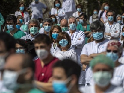 Health workers at the La Paz hospital in Madrid hold a minute of silence in tribute to a doctor who died from Covid-19.