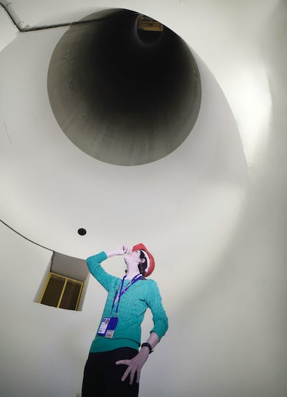 Fabiola Gianotti, la responsable del CERN, mira el enorme conducto utilizado para descender componentes pesados del Gran Acelerador de Hadrones.