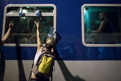 Voluntarios distribuyen botellas de agua entre los refugiados en la estación de tren de Hegyeshalom con destino a Budapest.