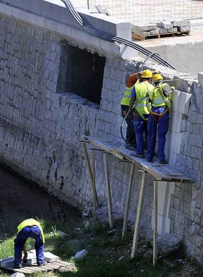 De los tres obreros subidos al andamio sólo uno está sujeto con un arnés. La ausencia de escalera sugiere una forma irregular para acceder a la estructura, según un técnico en prevención de riesgos laborales.