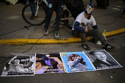 Un hombre sentado junto a carteles con fotografías de los líderes argentinos Juan Domingo Perón, la vicepresidenta Cristina Fernández de Kirchner y la ex primera dama Eva Perón, frente a la residencia de Fernández en Buenos Aires.