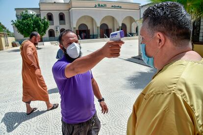 Un voluntario toma la temperatura a un hombre a la entrada de una mezquita en Argel, el 15 de agosto.