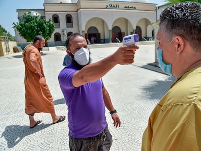 Un voluntario toma la temperatura a un hombre a la entrada de una mezquita en Argel, el 15 de agosto.