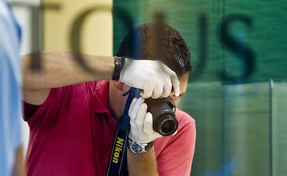 Un agente toma fotografías del interior de la joyería Tous del paseo de Gràcia tras ser atracada.