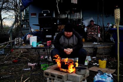 Christopher Bowlin, de 24 años, prepara la comida en el exterior de su casa destruida tras el paso del tornado en Mayfield (Kentucky). Miles de hogares están sin electricidad y es difícil hacer una predicción de cuándo retornará.