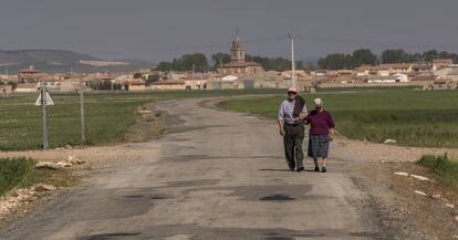 Dos vecinos pasean a las afueras del pueblo turulense de Bello.