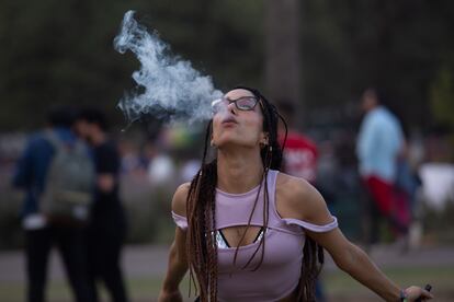 Una mujer exhala vapor de un cigarrillo electrónico.