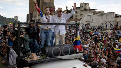 El candidato opositor Edmundo González y la líder María Corina Machado saludan a los partidarios que apoyan desde sus ventanas durante un acto de campaña en la ciudad de Valencia, Carabobo, el 13 de julio de 2024.