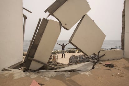 En la isla ghanesa de Kpogbor solo queda un habitante, que aparece en la imagen ante unas barreras que ha construido para proteger lo que queda de su vivienda. El aumento del nivel del mar y la erosión de la costa han hecho que el resto de los habitantes abandone el islote.