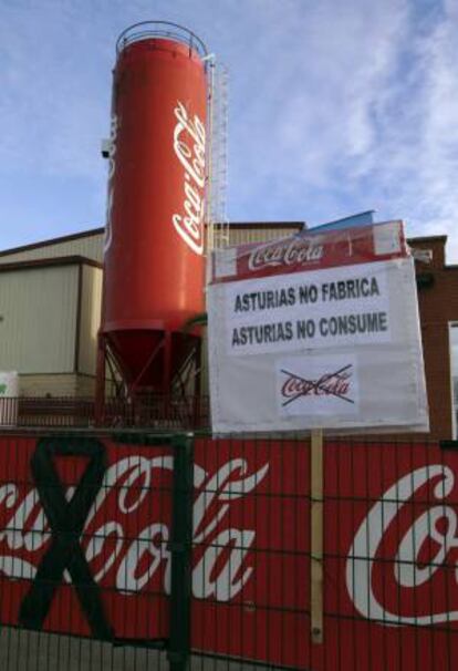 Carteles contra el cierre en la planta embotelladora de Coca-Cola en Colloto (Asturias), cuya plantilla tiene la intención de mantener la huelga indefinida iniciada el pasado lunes mientras la empresa Iberian Partners no retire el cierre de la actividad.