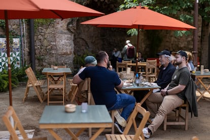 La Font del Gat es un espacio para comer al aire libre, lleno de mesas y sillas de madera.