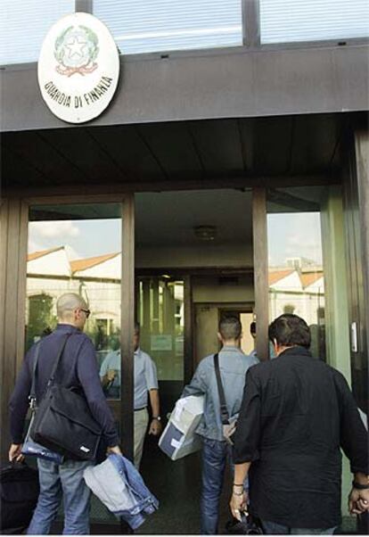 Agentes de la Policía de Finanzas entran en su sede de Florencia con material requisado en una redada.