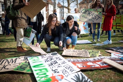 Los científicos están de acuerdo en que cargar la atmósfera con gases de efecto invernadero al ritmo actual, probablemente conducirá a un planeta en el que no se puede vivir. En la imagen, dos jóvenes preparan pancartas para participar en la marcha en Liubliana (Eslovenia).