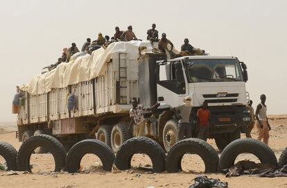 Os caminhões servem para transportar mercadoria e pessoas pelos diversos povoados do deserto. Na imagem, um dos caminhões de transporte espera para cruzar um bloqueio da polícia de Níger.